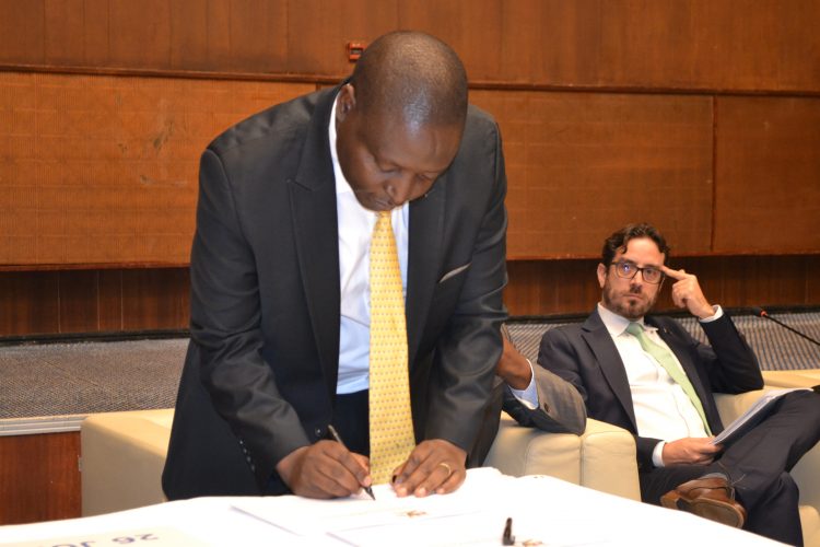 The state minister for finance,  David Bahati ,signing adaptation plans in Kampala