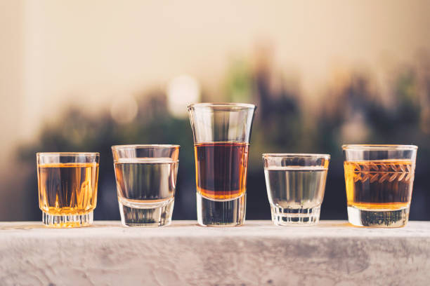 Five shot glasses filled with a variety of alcohol